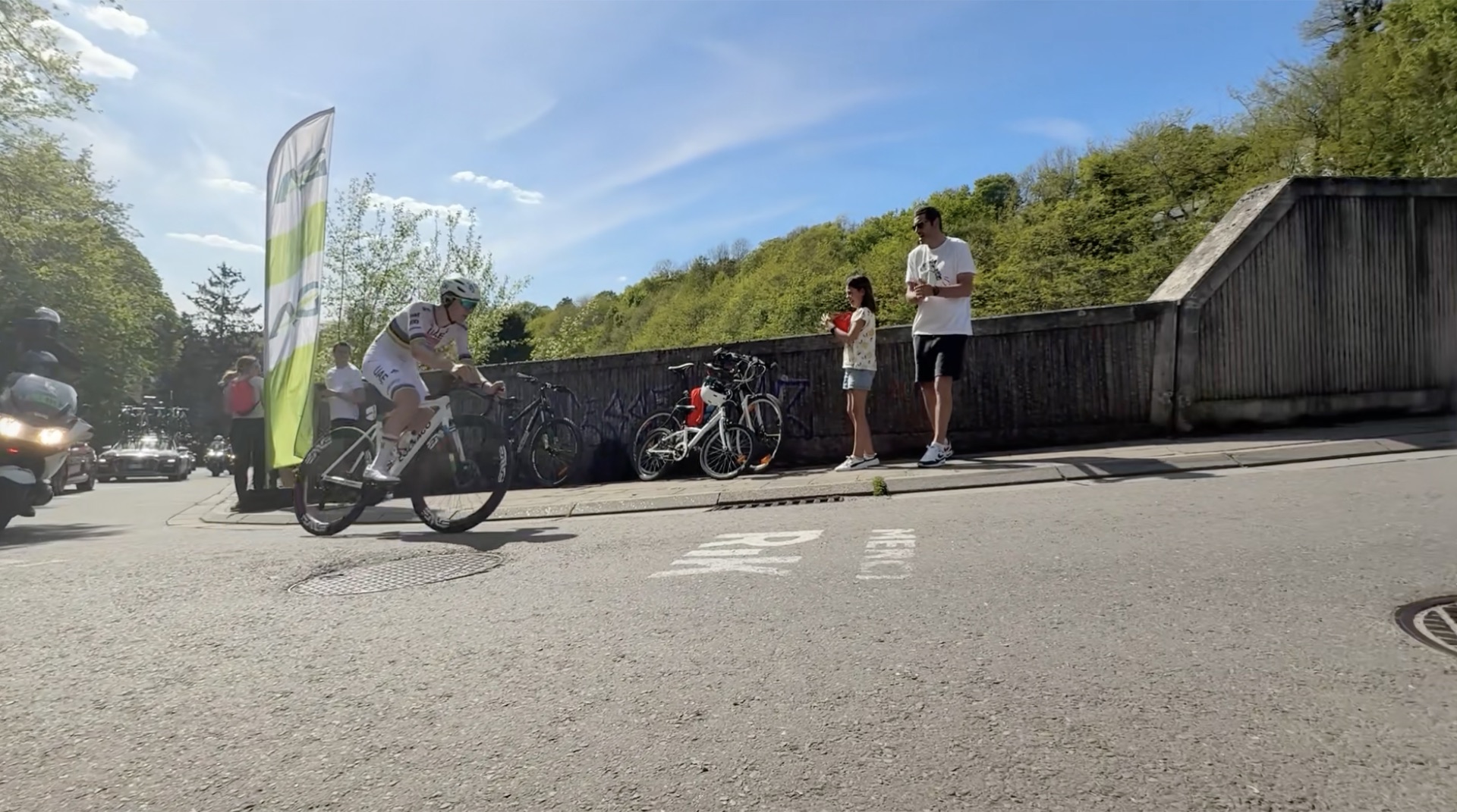 Tadej Pogačar in the rainbow world-champion jersey, riding solo past roadside fans